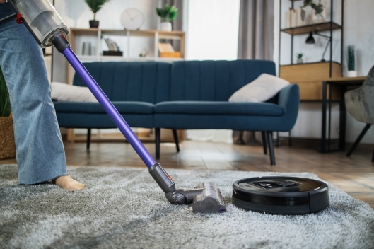 Close up of woman cleaning carpet with vacuum cleaners